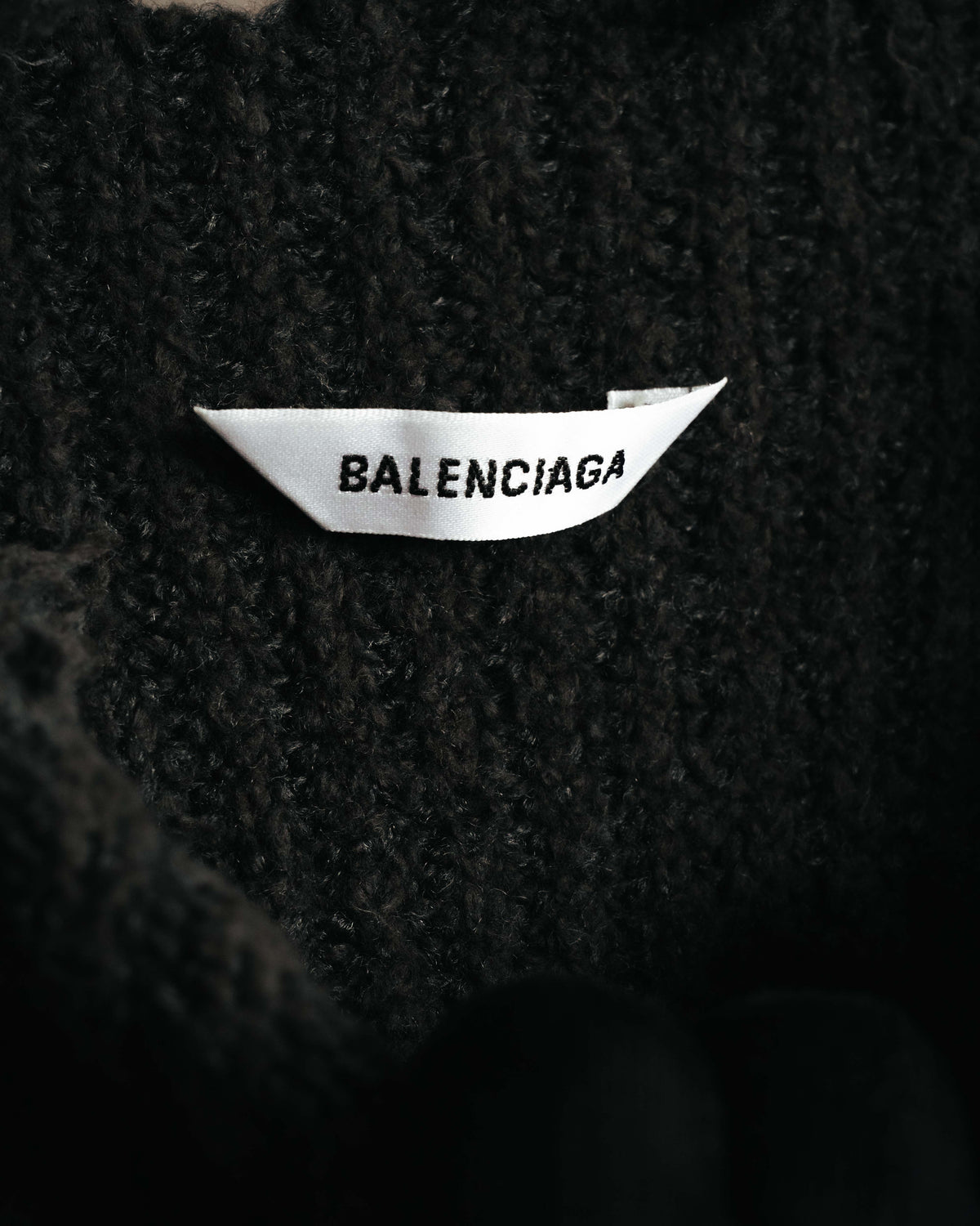 黒い畦編みの内側に配されたネックタグ。BALENCIAGAの表記を確認できるカットです。