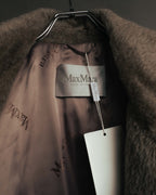 首元内側のMax Maraタグと、ブランドロゴが繰り返し配された光沢のある裏地を写したカット。毛足のある表地と裏地の質感の対比も確認できます。