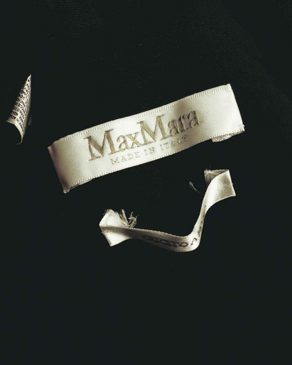 内側に配された淡いグレー系の織りネームを写したタグカット。Max Mara MADE IN ITALYの表記と、多国表記の品質表示タグを確認できます。