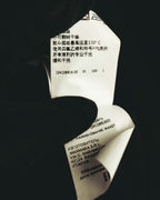 内側に配された多国表記の品質表示タグを写したカット。製造元表記とケア表示、品番が確認できる仕様です。