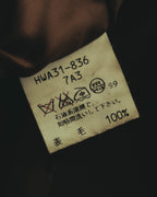裏地付近に配された日本語の品質表示タグのクローズアップ。表地は毛100%と記載され、製品管理番号と洗濯表示も確認できます。