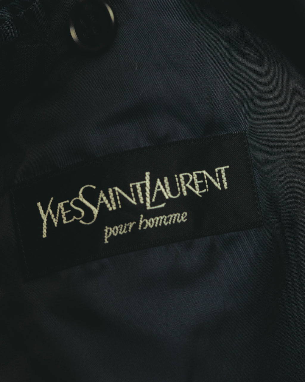 裏地に配された「Yves Saint Laurent pour homme」のブランドタグを写したカット。1990年代後半から2000年代にかけての製品背景に言及する箇所と照合しやすいディテールです。