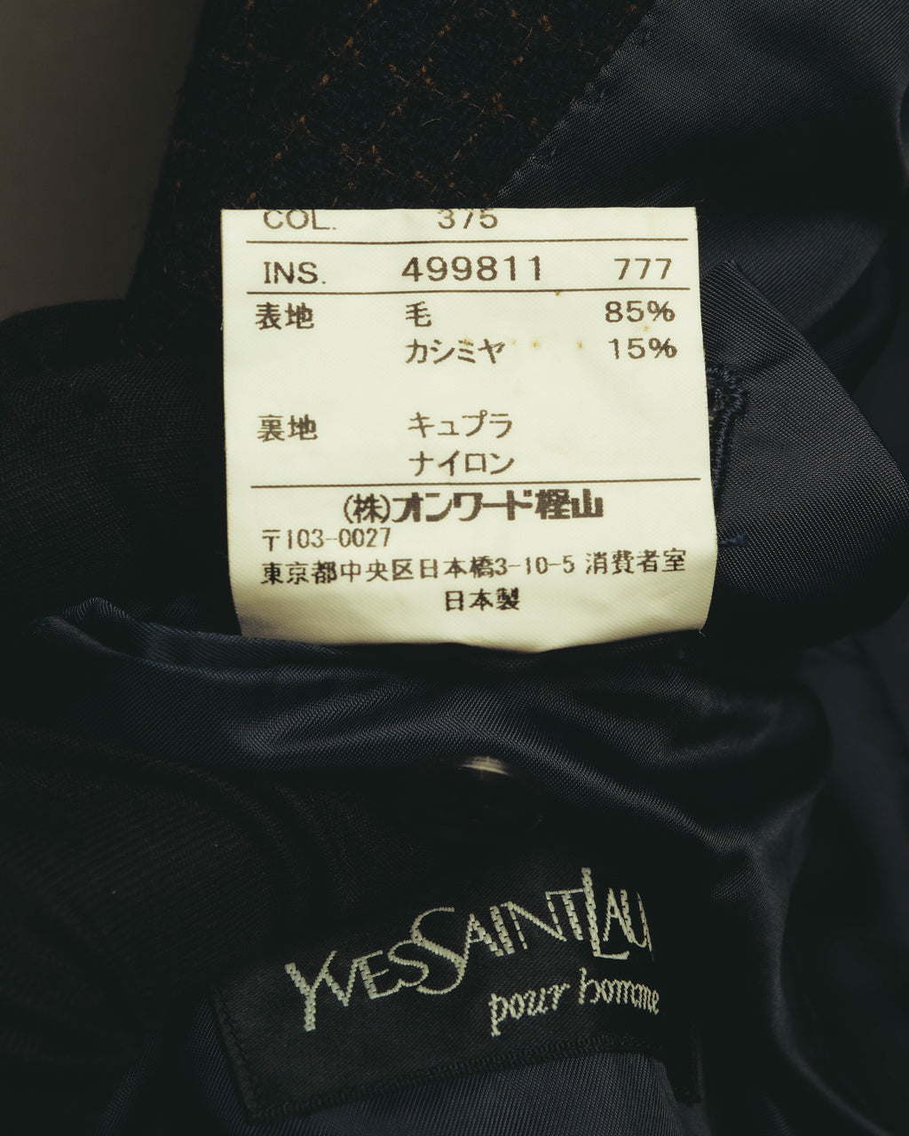 Yves Saint Laurent pour hommeのブランドタグと、表地が毛85％・カシミヤ15％であることを示す品質表示タグのカット。オンワード樫山および日本製の表記も確認できます。