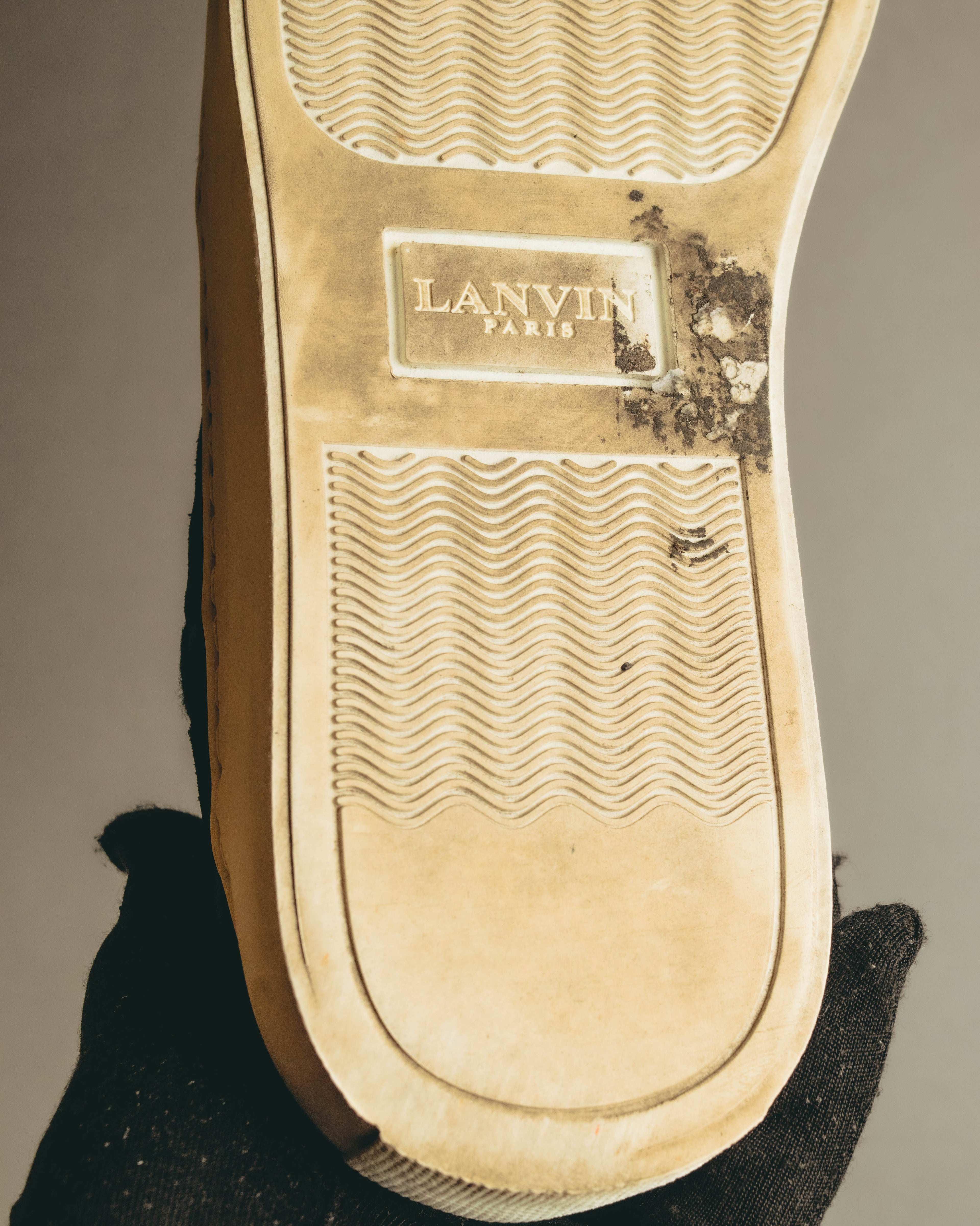 オフホワイト系ラバーアウトソール中央に配された「LANVIN PARIS」刻印のディテール。波状のトレッドパターンと、経年による黄味・使用感も確認できるカット。