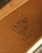 キャメルブラウン系の内装レザーに残るGUCCIの型押しと、旧式の盾状クレスト意匠を捉えたディテールカット。