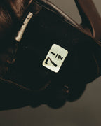 グローブ内側に配された、7 1/2のサイズ表記タグを捉えたカット。濃茶色の起毛素材と、カフ周辺のレザー縁の仕立ても確認できます。