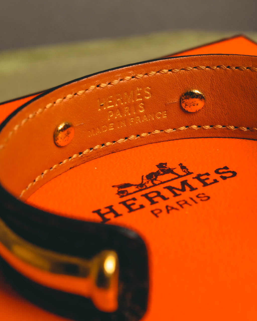 キャメルからブラウン系の滑らかな内側レザーに入る HERMÈS PARIS MADE IN FRANCE の金色刻印と、立体的な竹状パーツを固定するリベットを捉えたディテールカット。端部のステッチも確認できます。