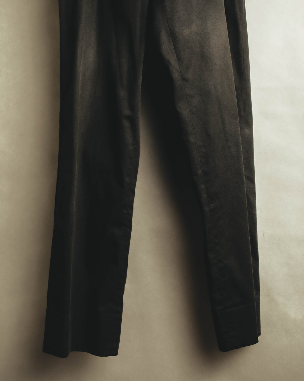 黒を基調とするコットン地の両脇に配された、細幅の羊革トリミングを捉えたディテールカット。裾へ向かって大きく広がらないストレート寄りのラインも確認できます。
