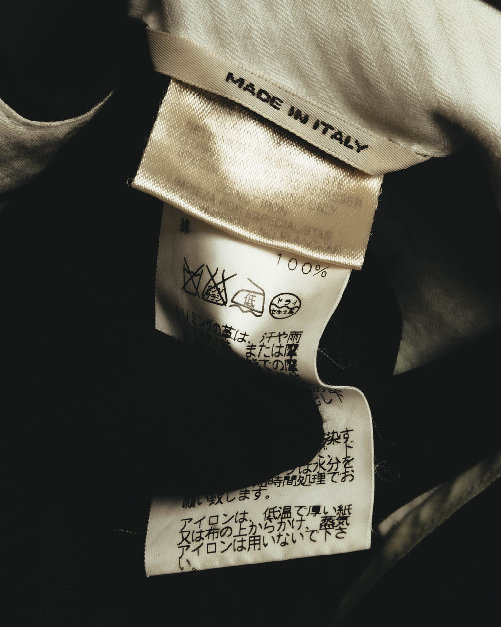 内側に配された「MADE IN ITALY」表記と、旧JIS洗濯表示が確認できる品質表示タグのカット。