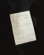 内側に配された旧式の品質表示タグ。表地は毛100パーセント、裏地はキュプラ100パーセントの表記と、品番・事業者識別コードが確認できるカット。