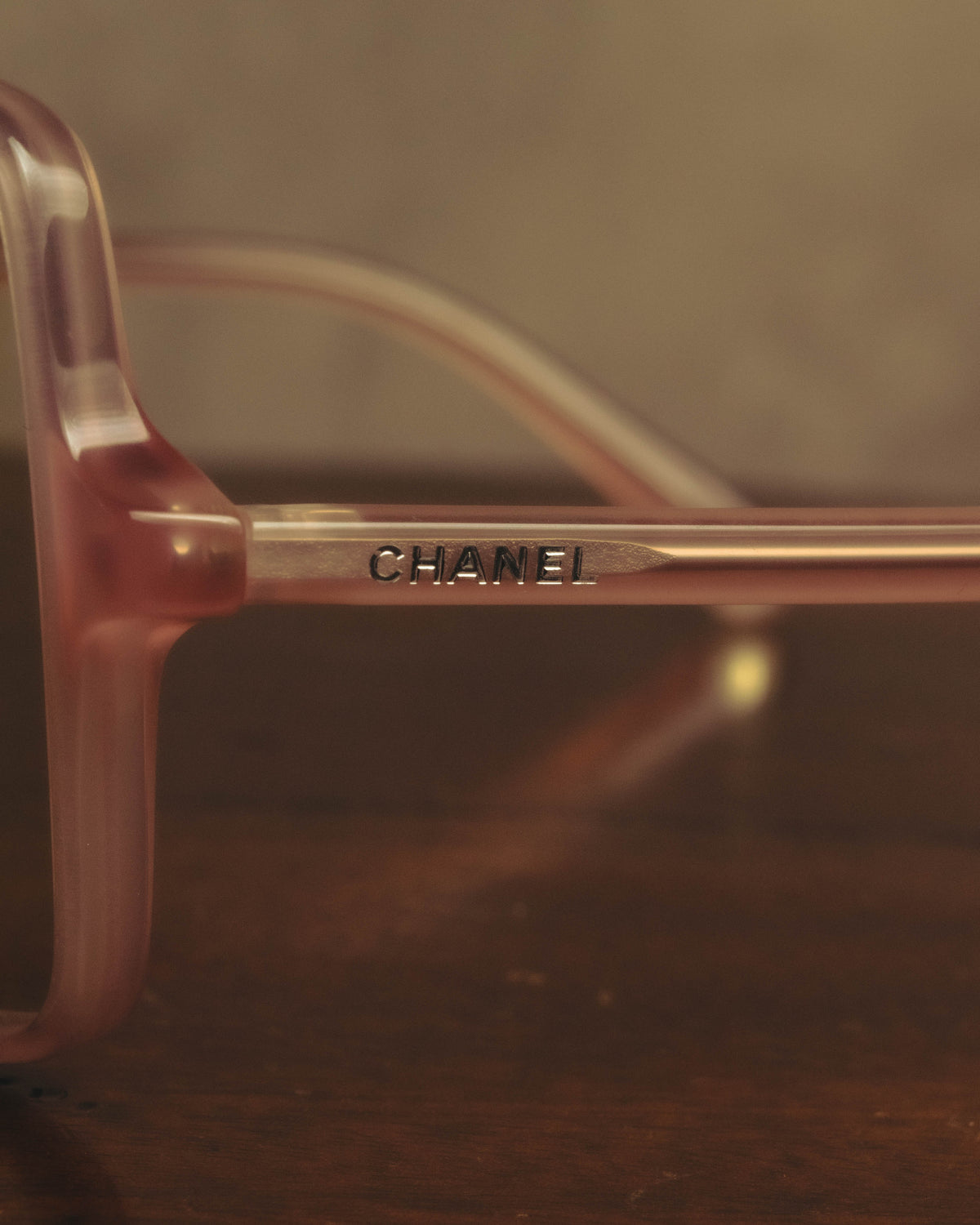 淡いピンクのアセテート製テンプルに配されたCHANELの文字を捉えたディテールカット。フロントからサイドへ視線を移した際に現れるロゴの印字が確認できます。
