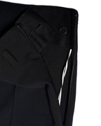 ウエスト内側に配されたボタンとコンシールファスナーのディテール。内装にはコットンのパイピングが施されています。