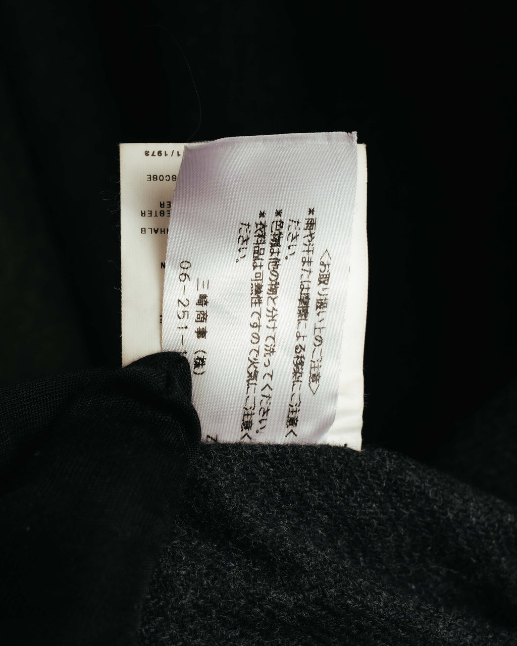 内側に縫い付けられた品質表示タグのカット。注意書きと番号表記が確認できる仕様です。