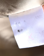 総裏仕立ての内側に配された品質表示タグのクローズアップ。表地・裏地の素材表記と「100%」の表記が確認できるカット。