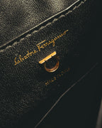 ブラックの内装に施された旧筆記体のSalvatore Ferragamoゴールド箔押しと、ショルダーストラップ用Dリングを捉えたディテールカット。