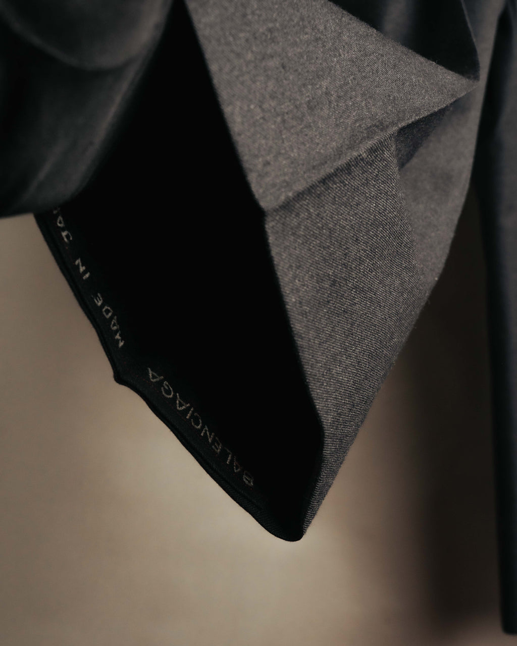 ウエスト内側に配されたブランドネーム入りの腰裏と、細やかな織りの表情を捉えたディテールカット。生成り色の腰裏ではなく、黒地の腰裏が確認できる。