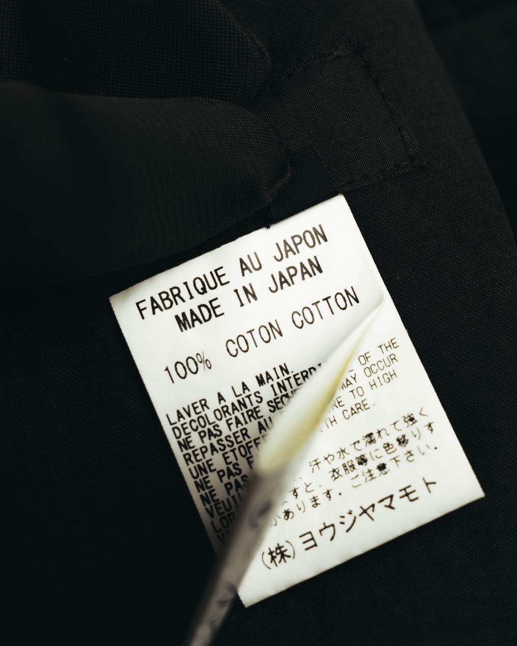 内側の洗濯表示タグを写したカット。日本製・コットン100%の表記を確認できます。