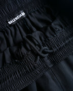 ゴム仕様のウエスト内側に配された「BALENCIAGA」ピスネームと、サイズ調整用ドローコードのディテール。力強いギャザーを施したイージーパンツ構造が確認できる。