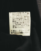 内側に配された洗濯表示タグのクローズアップ。スエード・ベロア表面のケアとクリーニング専門店への相談に関する表記が確認できます。