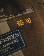黒地に旧表記のBurberrys'を配した主タグと、騎馬騎士モチーフの刺繍を捉えた内側のカット。カシミヤ混ウールの起毛感とキュプラ裏地も確認できます。