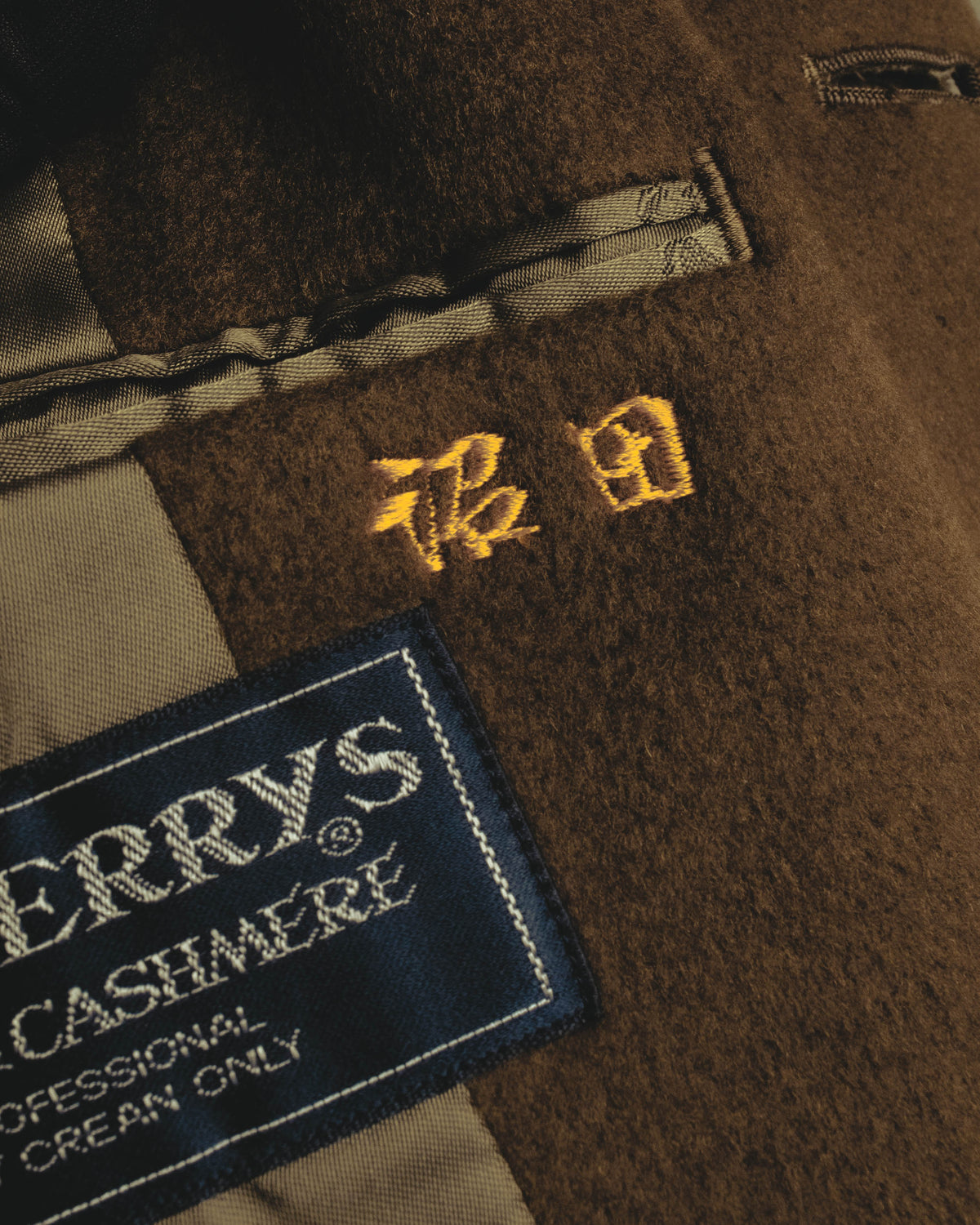 黒地に旧表記のBurberrys'を配した主タグと、騎馬騎士モチーフの刺繍を捉えた内側のカット。カシミヤ混ウールの起毛感とキュプラ裏地も確認できます。