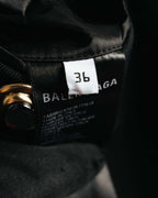襟元内側に配されたBALENCIAGA PARIS表記のブランドタグと、36表記のサイズタグを捉えたカット。周囲にはブラックの裏地とゴールドカラーの金属パーツが見える。