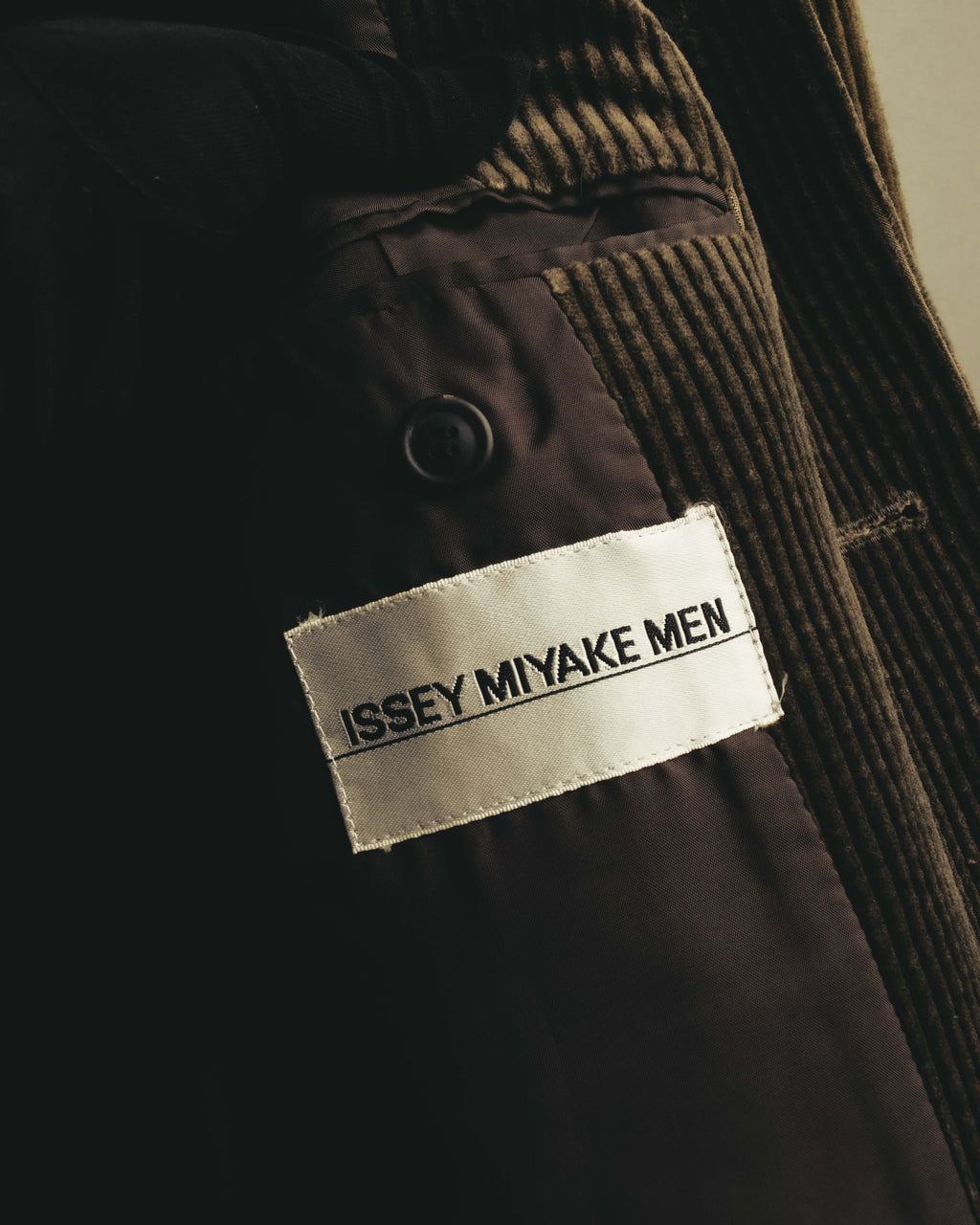 ISSEY MIYAKE MENのブランドネームが読める内タグのカット。太畝コーデュロイの内側に配された、滑らかな総裏のキュプラ裏地も確認できます。