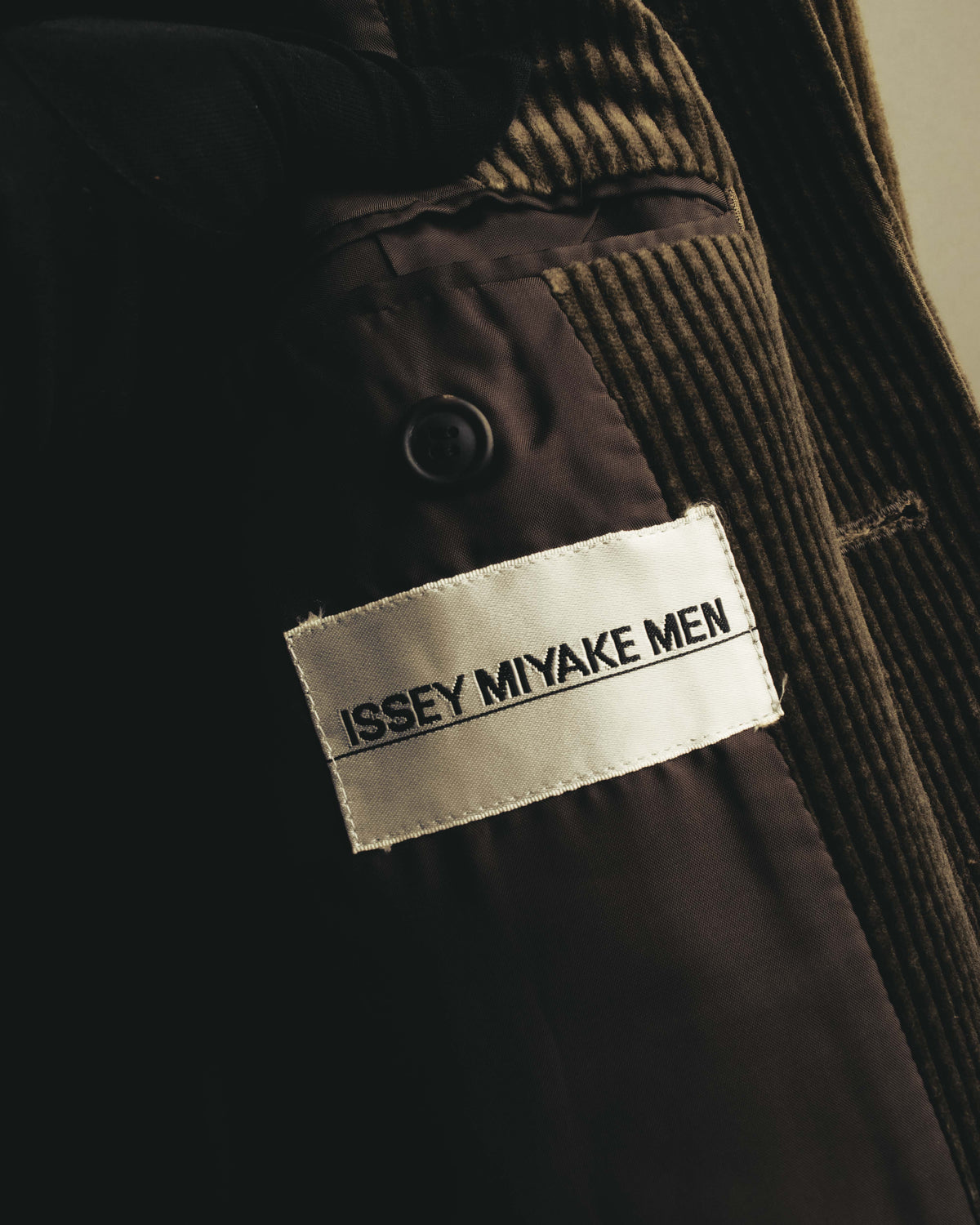 ISSEY MIYAKE MENのブランドネームが読める内タグのカット。太畝コーデュロイの内側に配された、滑らかな総裏のキュプラ裏地も確認できます。
