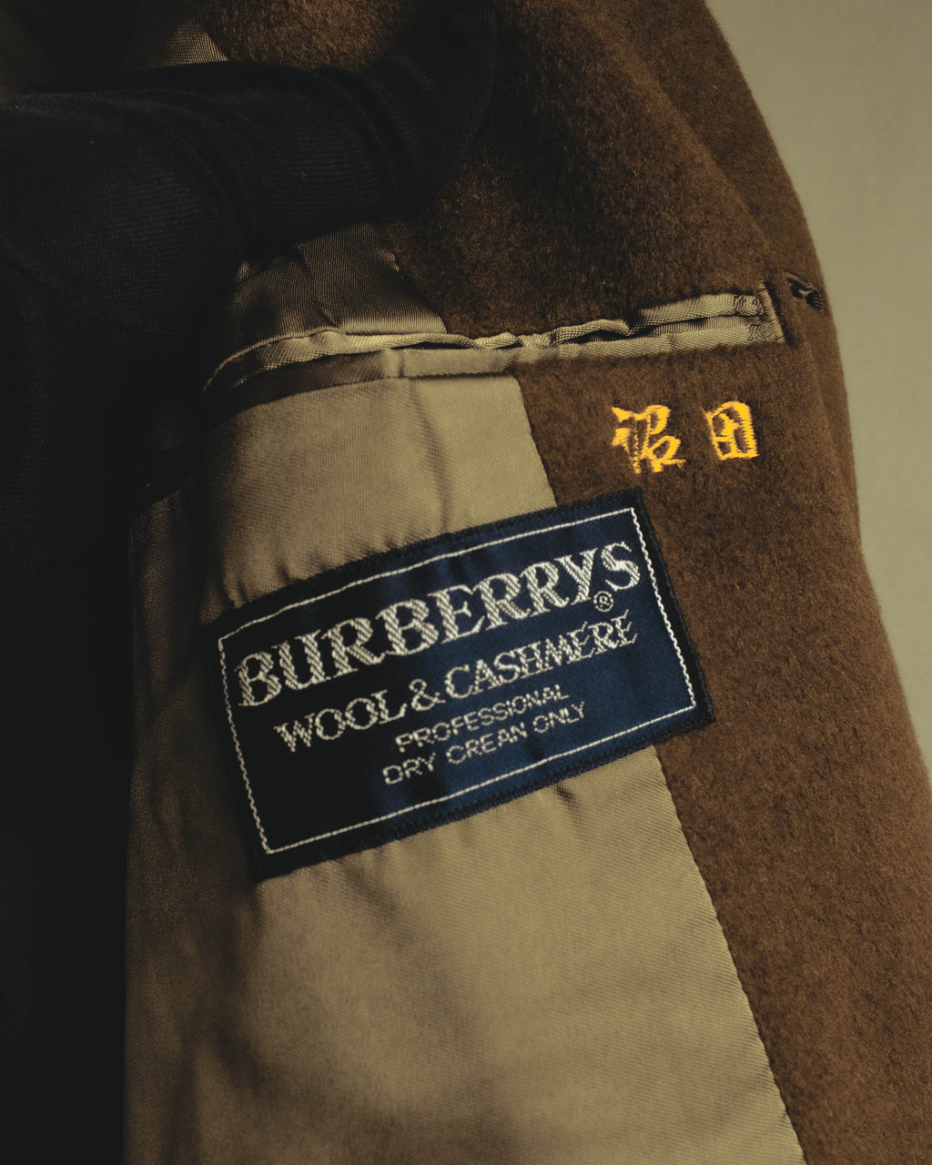 内側に配された「BURBERRYS' WOOL & CASHMERE」表記の品質表示タグを捉えたカット。ウールとカシミヤの素材表記、およびドライクリーニング表記が確認できます。