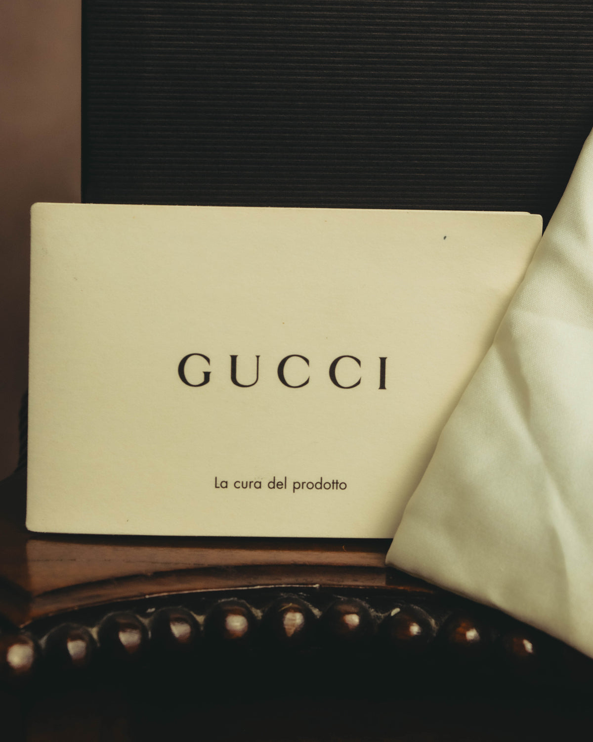参考付属品として揃うGUCCIのケア冊子とダストバッグを写したカット。冊子には「La cura del prodotto」の表記が確認できます。