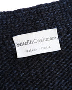 「Settefili Cashmere」と「FERRARA - ITALIA」の表記を確認できる、ダークネイビーのチャンキーニット内側のブランドネームタグ。
