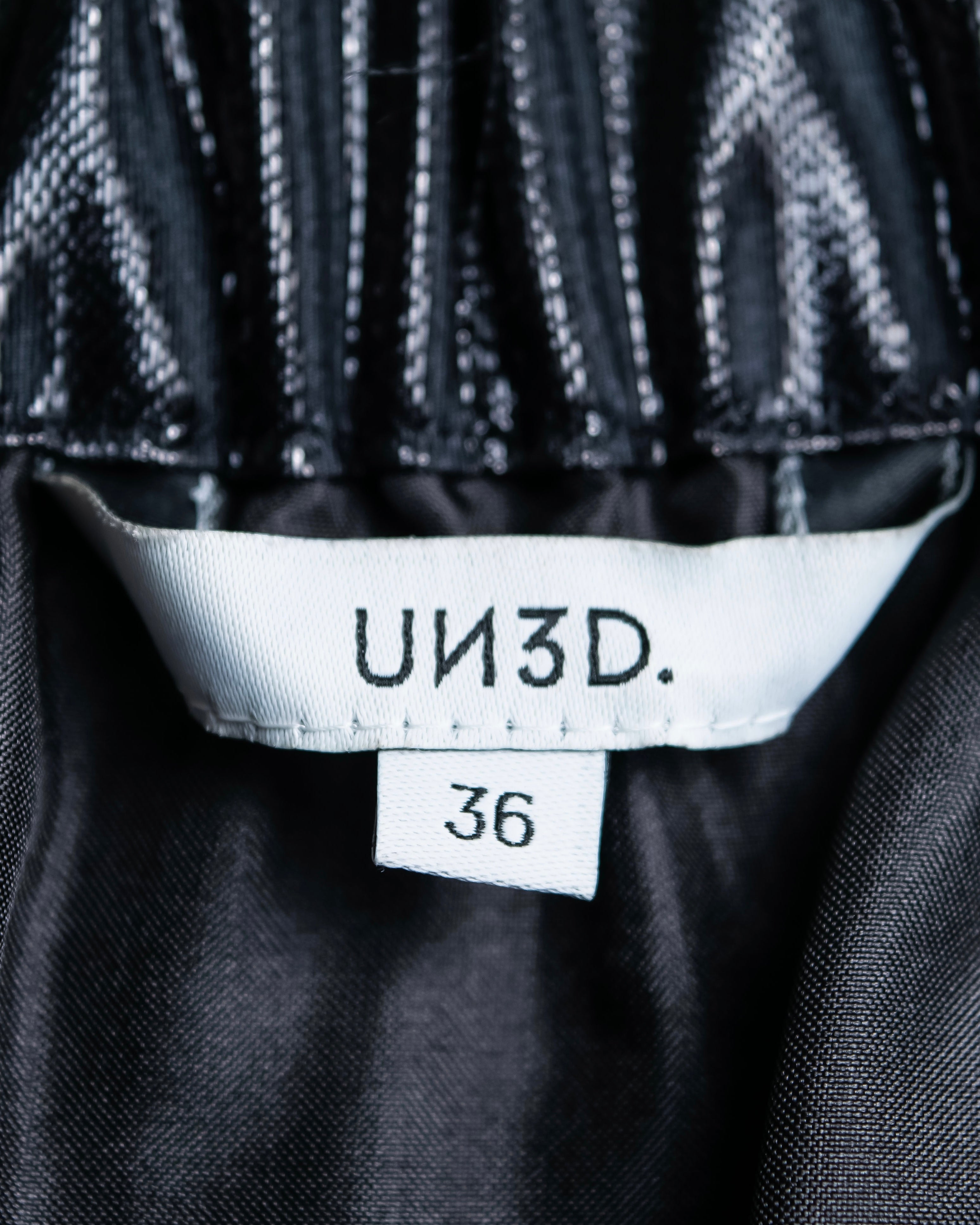 "UN3D." Shiny three-dimensional pleated skirt
